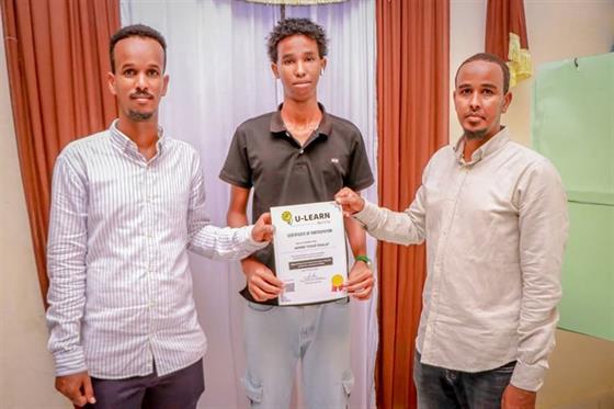 U-Learn Skills graduates holding their certificates at a graduation ceremony