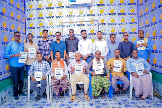 U-Learn Skills graduates holding their certificates at a graduation ceremony