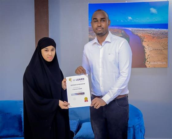 U-Learn Skills graduates holding their certificates at a graduation ceremony